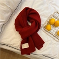 Festive red thick knitted scarf with vertical stripe texture and white label on bed - 30x175cm / Red (Letter Design)