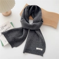 Close-up of dark grey cashmere knitted scarf texture and premium fabric brand label - Dark Gray