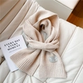 Detalle de bufanda de punto 100% lana con etiqueta de marca en el dobladillo acanalado - Beige
