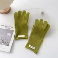 Primer plano de guantes de lana de punto verde oliva con una etiqueta blanca minimalista - Verde amarillento