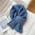 Close-up of thick grey-blue mohair knit scarf with leather patch on white leather sofa - Navy Blue