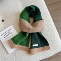 Detail of color-block knit scarf with rib texture and soft fringed edges on white rug - Three-color Patchwork Green (3D)