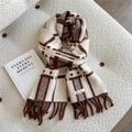 Detail eines weichen braun-beigen Strickschals mit Karomuster und Fransen auf Vlies - Beige Kariert (Doria Dore)
