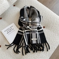 Nahaufnahme des dicken Strickschals mit Streifen, Fransen und Markenlabel auf Stoff - Schwarz Kariert (Doria Dore)