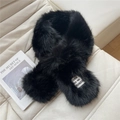 Close-up of black faux fur scarf featuring a white fashion brand label on soft leather - Black