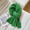 Dettaglio di sciarpa in lana verde brillante con trama a maglia su divano bianco - 30x170cm / Verde