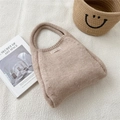 Detailed close-up of beige knitted handbag with handmade label and textured fabric surface - Off-white