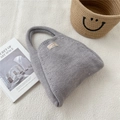 Close-up of grey knitted tote bag with thick texture on a white decorative surface - Light Gray