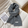 Detail of soft charcoal grey knitted scarf with brand label on a cozy white sofa - 20*160cm / Dark Gray