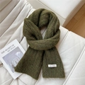 Close-up of moss green knitted scarf texture with a white fabric label on a sofa - 20*160cm / Dark Green