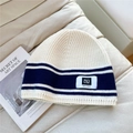 Gros plan détaillé du bonnet rayé montrant la texture du tricot et l'étiquette - Taille unique / Blanc Bleu Marine