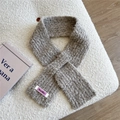 Close-up of a warm taupe knit scarf featuring a textured boucle surface and brand tag - Light Coffee