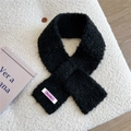 Nahaufnahme eines schwarzen Strickschals mit fliederfarbenem Wolllabel auf weißem Grund - Schwarz
