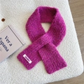 Nahaufnahme der rosa Strickschal-Textur mit weißem Webetikett auf weichem Stoff - Fuchsia