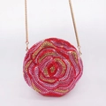 Dettaglio di strass rossi e dorati con trama a petali di rosa su borsa da sera tonda - Rosso Misto