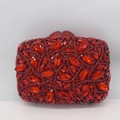 Close-up of vibrant red crystal evening clutch bag with detailed metal leaf clasp - Red