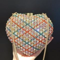 Macro view of heart-shaped clutch bag with colorful rhinestones and gold chain - Gold Multicolor