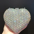 Macro view of heart-shaped luxury clutch bag with iridescent rhinestones and silver metal frame - Silver AB