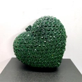 Detailed view of heart-shaped clutch bag with emerald green crystals and metal clasp - Emerald