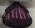 Close-up of a rhinestone evening bag with vertical rainbow stripes on a black base - Colorful Purple