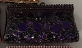 Dettagli di lussuosi strass viola e gemme sfaccettate su pochette da sera - Viola