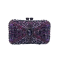 Close-up of a purple evening clutch bag with intricate crystal rhinestones and metal clasp - Purple