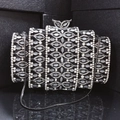 Macro shot of tiered black evening clutch with crystal inlay and silver bow clasp - Black
