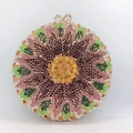 Close-up of sunburst flower pattern on sparkling crystal clutch with heart clasp - Gold Purple Green