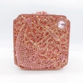 Detailed view of pink crystal rhinestones and gold floral vine patterns on a clutch bag - Pink