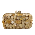 Macro detail of agate evening clutch with polished stones and bow-shaped gold clasp - Gold