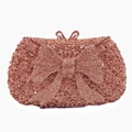 Detailed close-up of rose gold bow clutch bag with sparkling hand-set rhinestones - Champagne