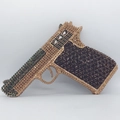 Detail view of handgun shaped evening clutch bag with gold and green rhinestones - Black Gold Green