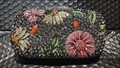 Dettaglio della lussuosa borsa da sera con cristalli colorati incastonati e motivi floreali - Grigio