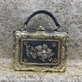 Detalle de los adornos florales de cristal y el marco dorado en relieve del bolso de noche - Gris