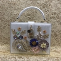 White shell晚宴包 featuring floral accents, sparkling rhinestones, and elegant pearls - White