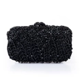Detailed view of luxury black crystal floral embroidery on a metal evening clutch bag - Black