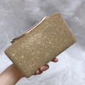 Detailopname van gouden avondtas met glinsterende strassteentjes en metalen sluiting - Goud