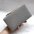 Detailopname van een rechthoekige avondclutch bezet met fonkelende zilveren strass - Zilver