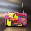 Detailed view of colorful toucan pattern rhinestones on a purple evening clutch bag - Toucan Pattern (Toucan) / Rose Red