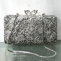 Detailed view of silver crystal evening bag with floral rhinestones and bow clasp - Silver