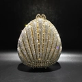 Nahaufnahme der muschelförmigen Abendtasche mit dichten, funkelnden Kristall-Strasssteinen - Gold