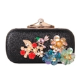 Detailed close-up of 3D resin flowers, sequin birds, and crystals on a black clutch bag - Black