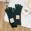Detailed texture of dark green knitted gloves featuring a retro woven brand label - One Size / Dark Green