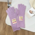 Detail of purple knitted gloves with letter patch, soft wool texture for winter warmth - One Size / Purple