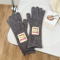 Detail of grey knitted gloves featuring a colorful Doria Dore fashion alphabet patch - One Size / Gray