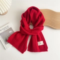 Close-up of red knit scarf with textured vertical stripes and minimalist emo woven label - Red