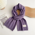 Detailed texture of purple ribbed knit scarf with a minimalist emo fabric label - Purple