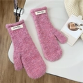 Detailed close-up of pink fluffy mitten featuring white brand label on soft curly plush fabric - Pink