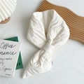 Primer plano de bufanda acolchada beige con ranura cruzada sobre bandeja de madera mínima - Blanco