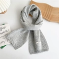 Detalle de la bufanda de lana de punto con textura jaspeada y etiqueta de material - Gris Claro Moteado